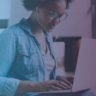 African American woman with headphones using a laptop